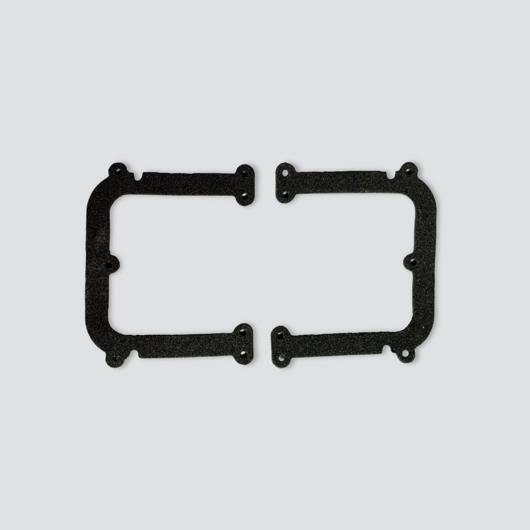 Two black gasket pieces with pre-drilled mounting holes, displayed flat against a light grey background.